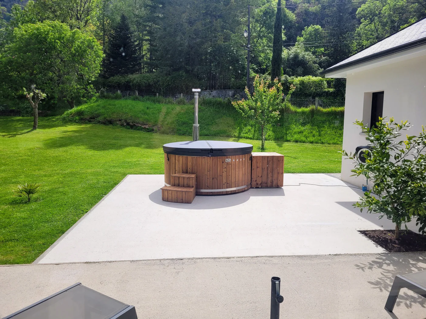Entretenir un bain nordique en bois : une routine adaptée à sa construction 2 Bain nordique TimberIN installé sur une terrasse claire au bord d’un jardin